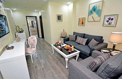 a living room with a couch and a table at Golden Bujari AlUlaya Hotel in Al Khobar
