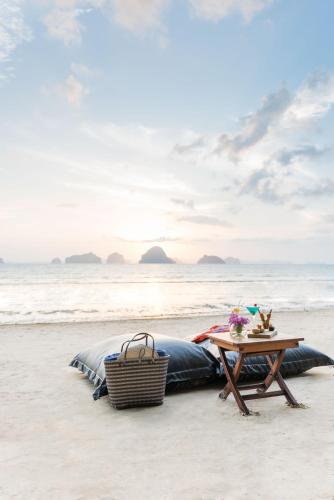a picnic table on the beach next to a tent at The Tubkaak Krabi Boutique Resort in Tab Kaek Beach