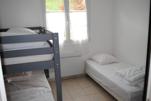een slaapkamer met 2 stapelbedden en een raam bij gîte la belle vue in Saint-Martin-en-Campagne