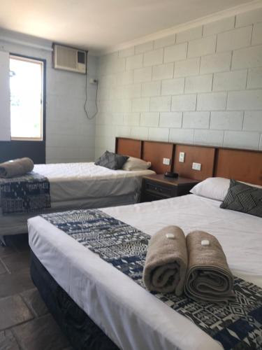 a hotel room with two beds with towels on them at Longreach Most Central Motel in Longreach