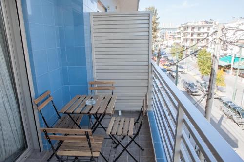 a table and chairs on a balcony with a view of a city at Lak Peristeri Homes 50m from metro station in Athens