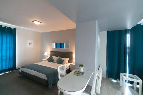 um quarto com uma cama, uma mesa e uma secretária em The Conroy Boutique Hotel em Amã