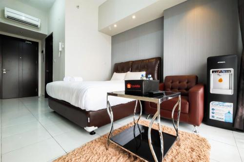 a bedroom with a bed and a table and a couch at Exclusive Studio Casa de Parco Apartment By Travelio in Jati