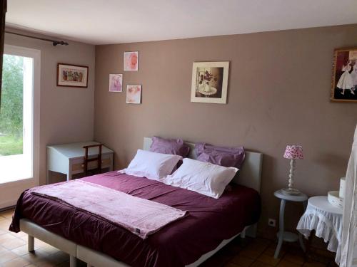 - une chambre dotée d'un lit avec des draps violets dans l'établissement Le clos des vergers, à LʼIsle-sur-la-Sorgue