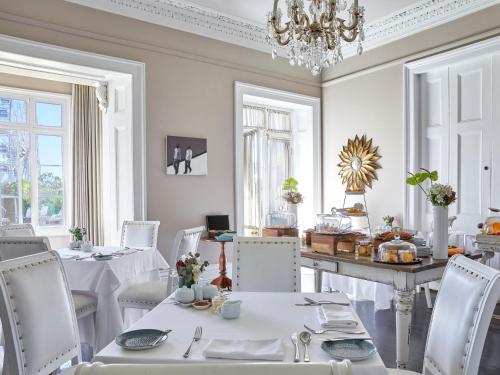 a dining room table with a white table cloth at Dock House Boutique Hotel and Spa in Cape Town