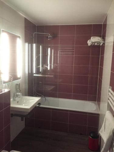 a bathroom with a sink and a bath tub and a sink at Le Clos De Mutigny in La Chaussée-sur-Marne