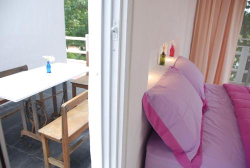 a room with a purple pillow next to a table at Baantantara in Suan Phung