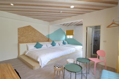 Un dormitorio con una cama grande y dos sillas. en 爸爸萬歲 PA Pa B&b 民宿2143號, en Hualien City