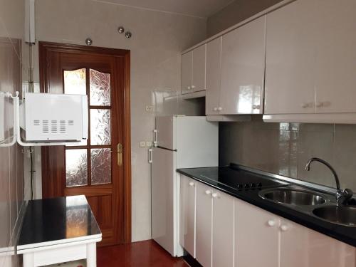 ロンダにあるApartamento Molino Rondaの白いキャビネット、シンク、窓付きのキッチン
