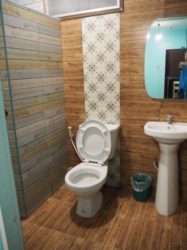 a bathroom with a toilet and a sink at Baantantara in Suan Phung
