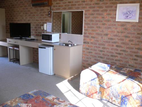 a room with a counter with a sink and a microwave at Settlement Motor Inn in Deniliquin