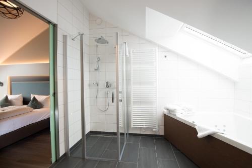 a bathroom with a walk in shower and a sink at Stadthotel Freiburg Kolping Hotels & Resorts in Freiburg im Breisgau