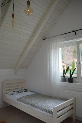 a bed in a room with a window at Biały Domek in Tylmanowa