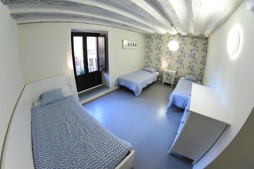 パンプローナにあるPlaza Catedral hostelのベッド2台とテレビが備わる客室です。