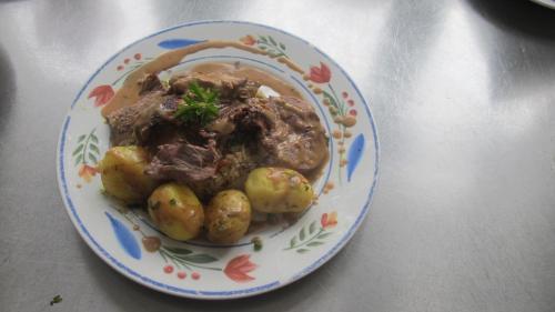 a plate of food with meat and potatoes on a table at Guesthouse Sharon Aarhus in Aarhus