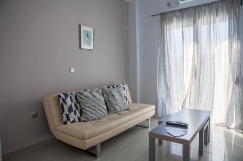 a living room with a couch and a coffee table at Lak Peristeri Homes 50m from metro station in Athens
