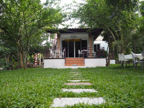 a house with a pathway leading to the front yard at Baantantara in Suan Phung