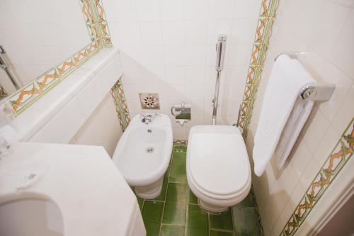 mała łazienka z 2 toaletami i umywalką w obiekcie Albergaria Senhora do Monte w Lizbonie