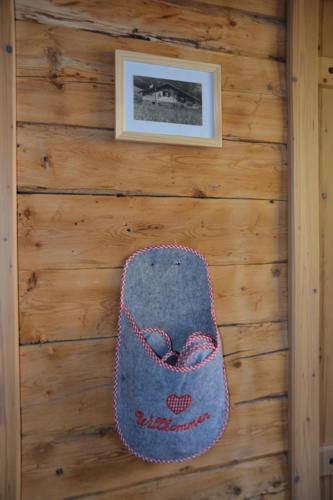a rug hanging on a wooden wall with a picture at Ferienwohnung Dienerhof in Großkirchheim