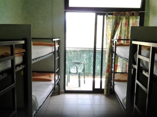 um quarto com beliches e uma janela com uma cadeira em chez marie em Porto Ota