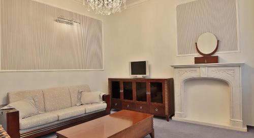 a living room with a couch and a fireplace at Sun Palace Wellness Hotel in Mariánské Lázně