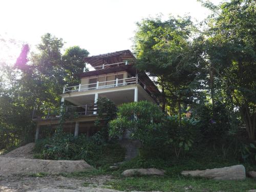 a house on top of a hill with trees at Baantantara in Suan Phung