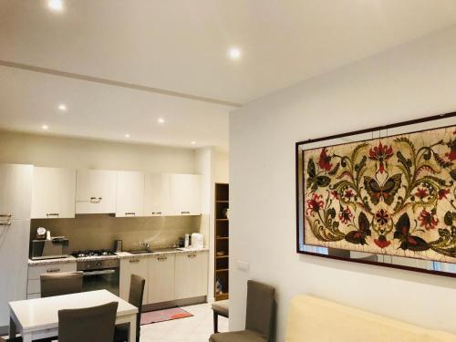 a kitchen and dining room with a painting on the wall at ApartmentsPadova in Padova