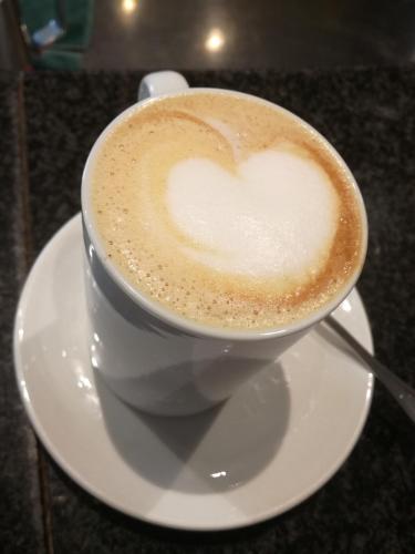 a cup of coffee on a plate on a table at Hotel Del Riale in Parabiago