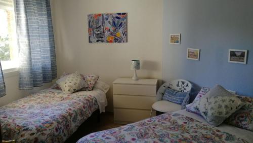 トレモリノスにあるApartamento Playasol Gardenのベッドルーム1室(ツインベッド2台、椅子付)