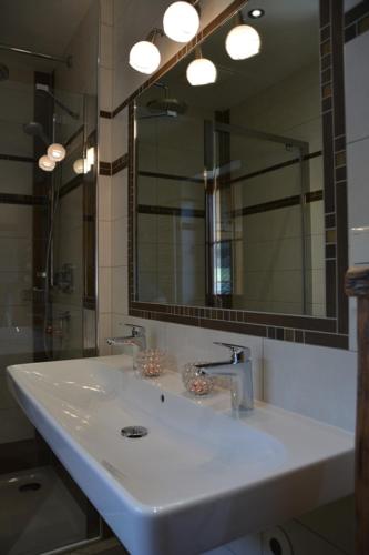 a bathroom with a white sink and a mirror at Ferienwohnung Dienerhof in Großkirchheim
