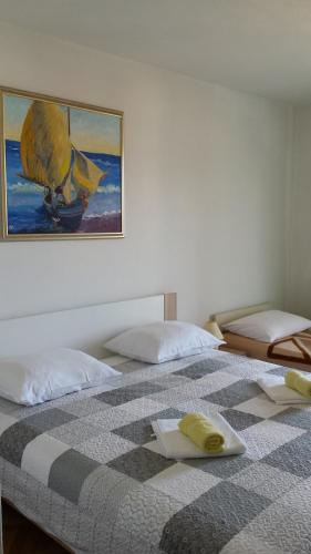 two beds in a room with a picture on the wall at Guesthouse Familija Tariba in Supetarska Draga
