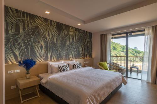a bedroom with a large bed and a large window at Panan Krabi Resort in Ao Nang Beach