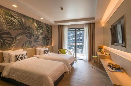 a hotel room with two beds and a large painting at Panan Krabi Resort in Ao Nang Beach