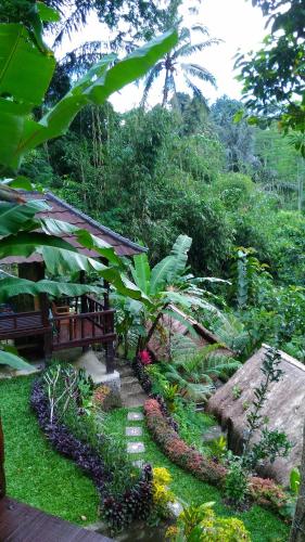 a garden with a bench and some plants and trees at Bali Jungle Resort in Tegalalang