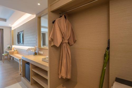 a bathroom with a robe hanging on a wall at Panan Krabi Resort in Ao Nang Beach