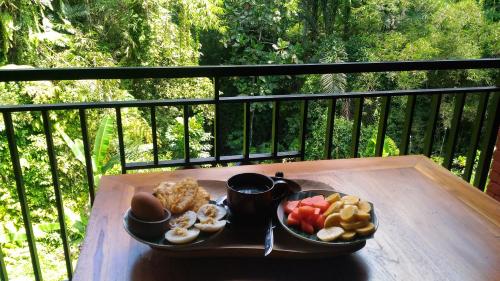 a tray of breakfast food on a table on a balcony at Bali Jungle Resort in Tegalalang