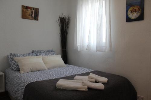 1 dormitorio con 1 cama con 2 toallas en Acacias Apartment, en Madrid