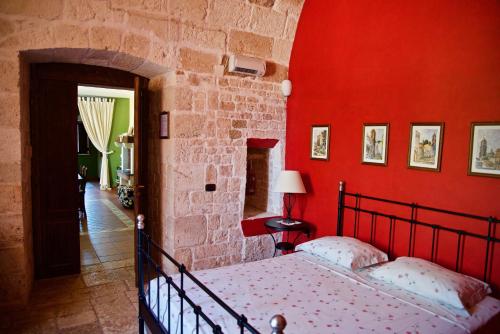 ein Schlafzimmer mit einer roten Wand und einem Bett darin in der Unterkunft Donna Isabella in Conversano