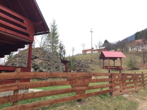 a wooden fence in front of a building with a gazebo at Deea Cascada in Vidra