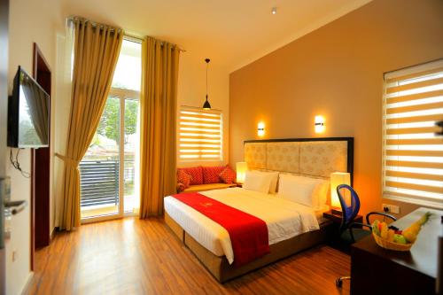 a bedroom with a bed and a large window at Ripon Grand Hill By EHI in Nuwara Eliya