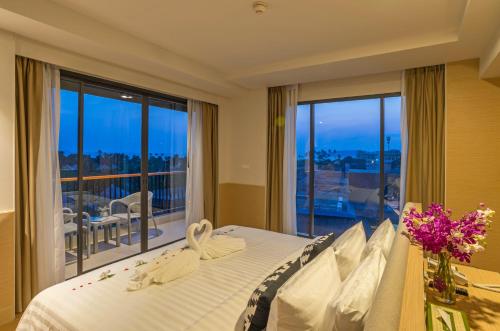 a bedroom with a bed with a view of a balcony at Panan Krabi Resort in Ao Nang Beach