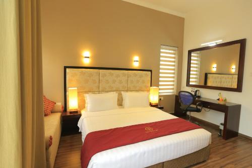 a bedroom with a bed and a desk and a mirror at Ripon Grand Hill By EHI in Nuwara Eliya