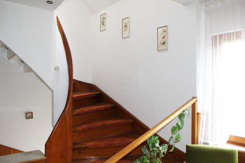 a staircase in a home with white walls and a green chair at Green Corner Nürburg in Nürburg