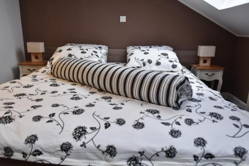 a bed with a black and white blanket and pillows at Center Apartment Čakovec in Čakovec