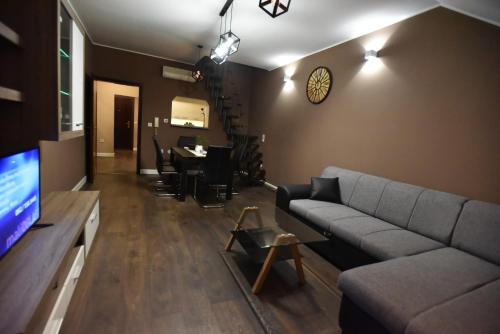 a living room with a couch and a tv at Center Apartment Čakovec in Čakovec