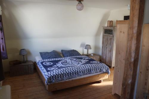 ラーデボイルにあるFerienhaus Wittaのベッドルーム1室(青と白の掛け布団付きのベッド1台付)