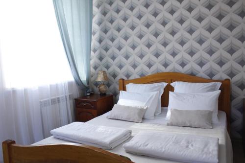1 dormitorio con 2 camas con sábanas y almohadas blancas en Mini-hotel Ostrov en Aleksandrov