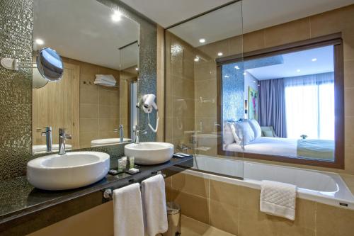 a bathroom with two sinks and a large mirror at Be Live Collection Marrakech Adults Only All inclusive in Marrakech