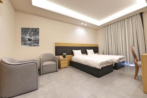 a bedroom with a bed and a table and chairs at The Residence 649 in An Naqqāsh