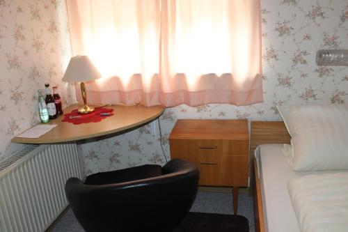 a bedroom with a chair and a desk and a bed at Green Corner Nürburg in Nürburg